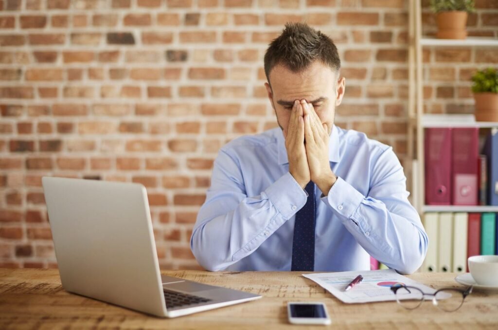 stressed-business-man-in-office-with-hands-on-face